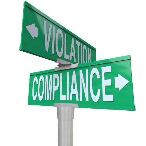 A green street sign with white letters points "Violation" in one direction and "Compliance" in the other.