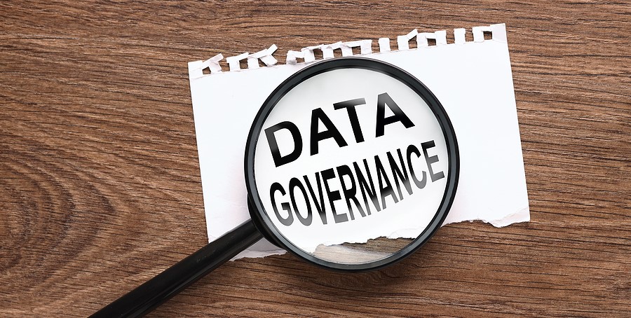 DataSafe staff looking at a data governance document through a magnifying glass in a Portland , OR office.